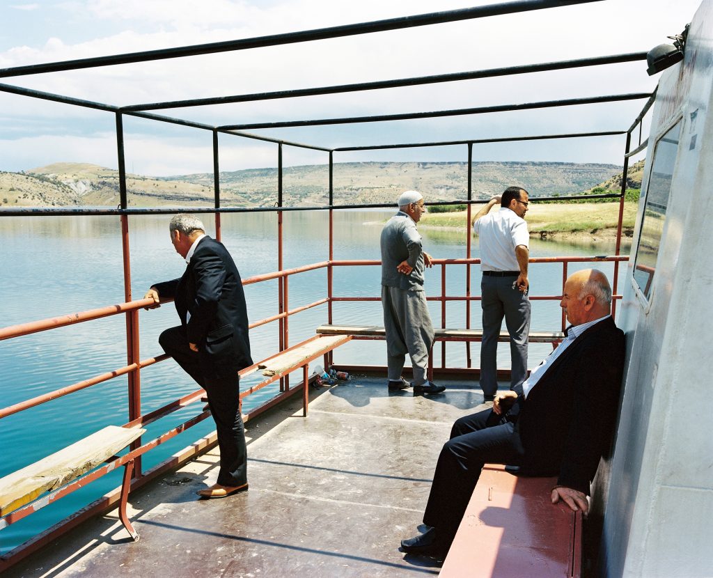 Men on a ferry boat travelling across the euphrates river near the Keban dam in eastern Anatolia. Keban, Turkey